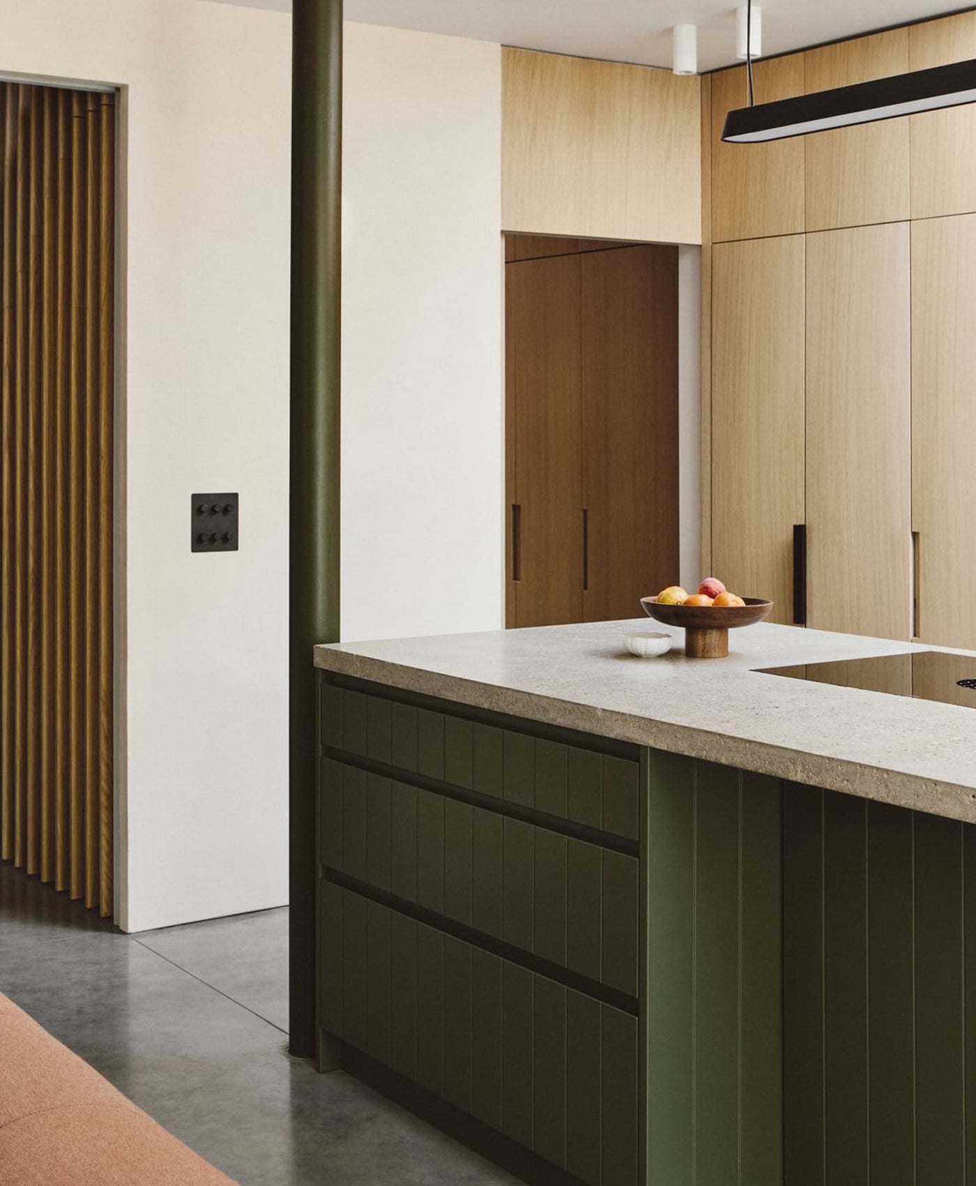 Modern kitchen with a olive green island and wooden cabinets.