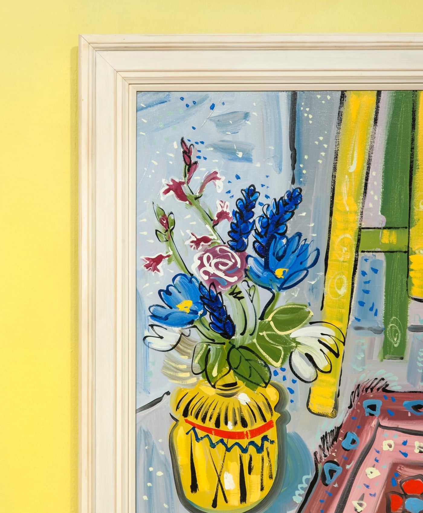 Framed artwork of a colorful floral arrangement with a yellow vase on a yellow wall.