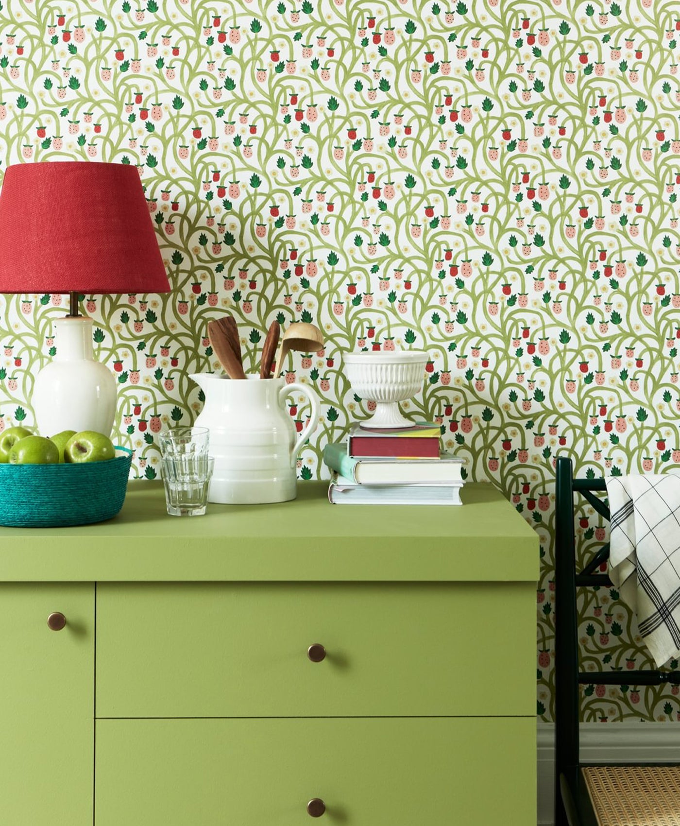 olive Green dresser with decorative items against a patterned wallpaper