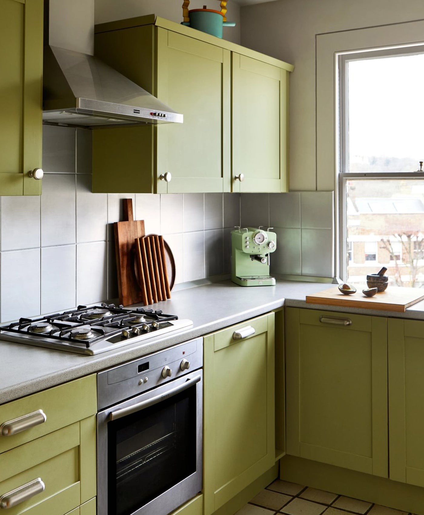 Lime green kitchen with stove, cabinets, and window