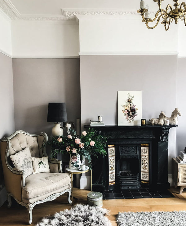 victorian Living room painted in a warm grey with a fireplace, armchair, and decorative elements.