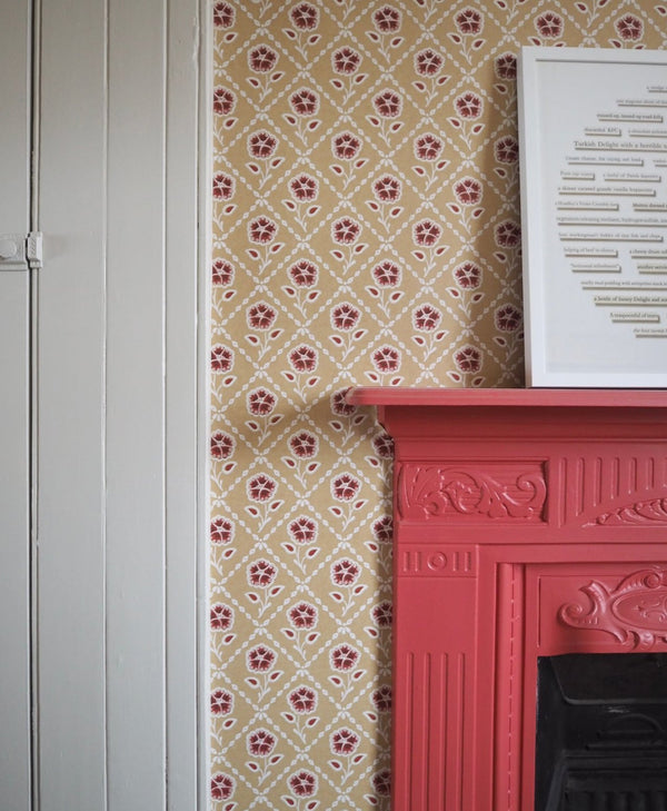 Red fireplace against a patterned wallpaper wall