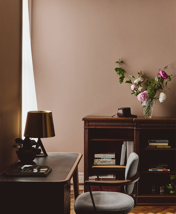 Home office in plaster pink paint with desk, chair, and bookshelf
