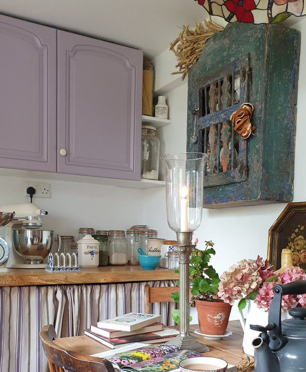 Kitchen with purple cabinets, wooden counter, and decorative items.