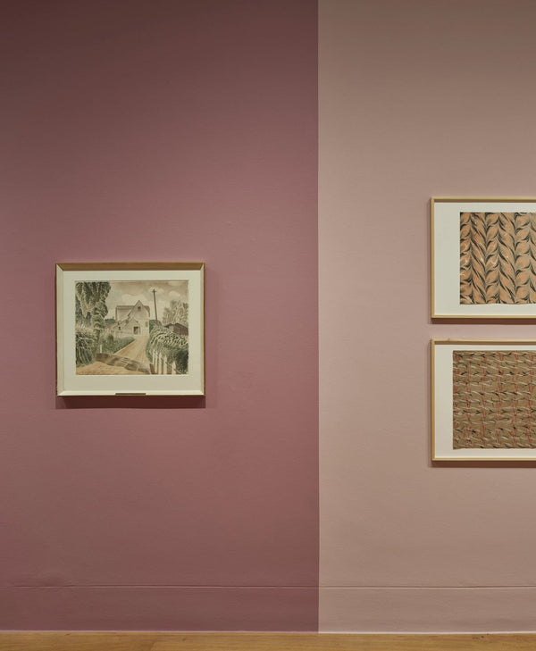 Three framed artworks on a wall with a dusty pink two-tone color scheme.