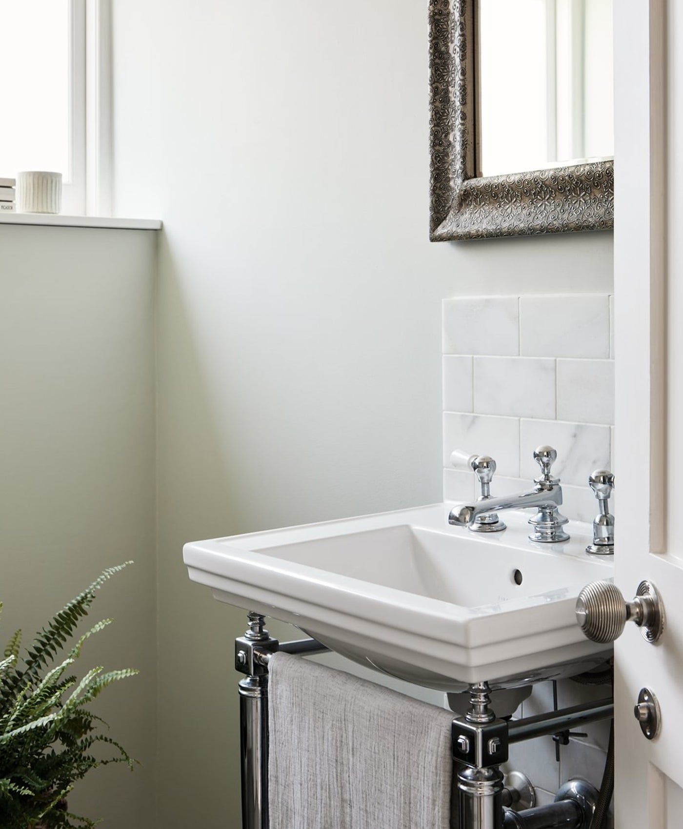 mint green Bathroom sink with chrome fixtures and a plant in the corner.