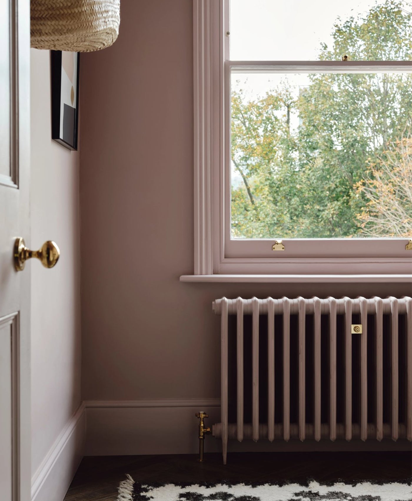 dusty pink Radiator and wall with a window and door in the background