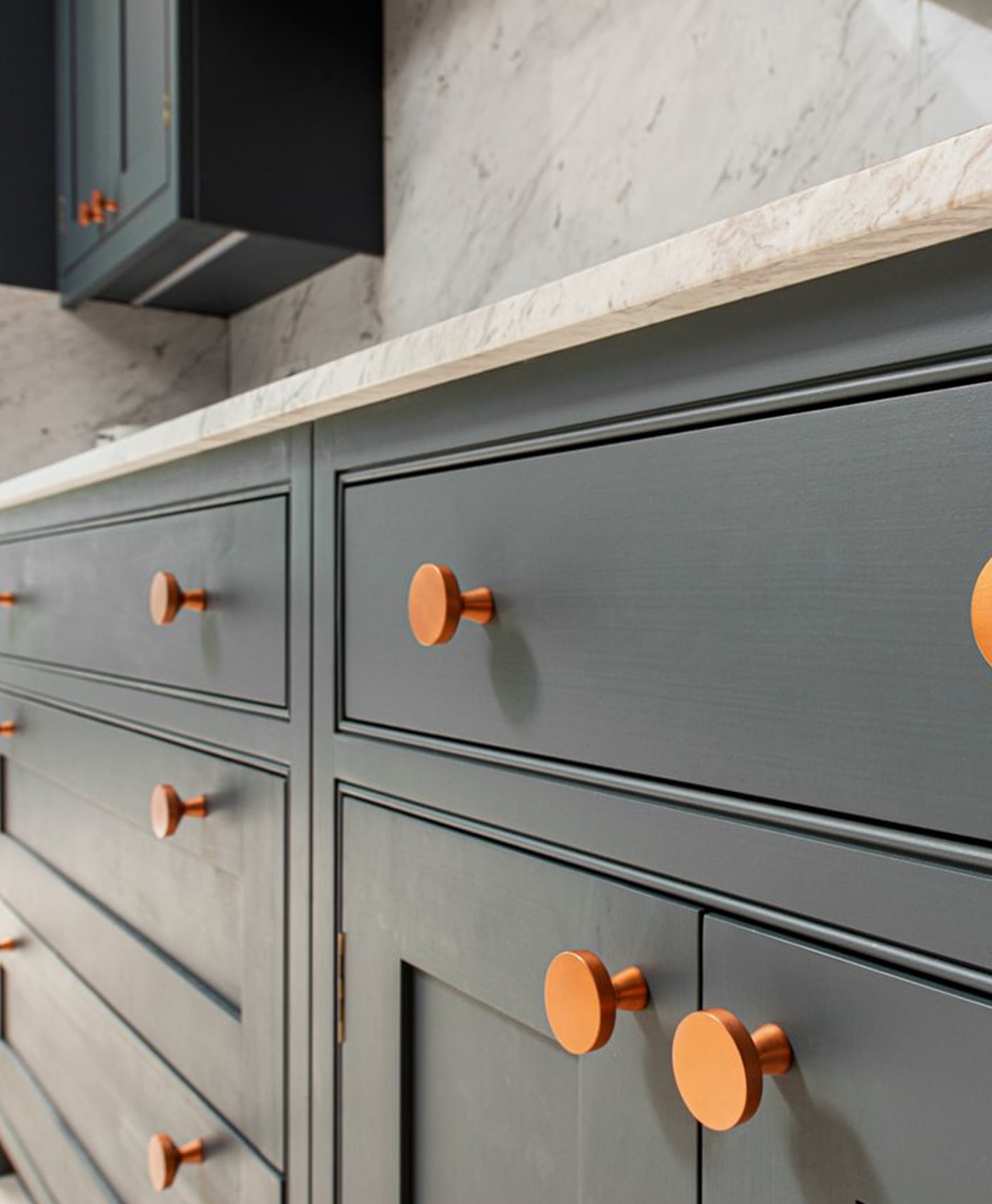 Ink grey kitchen cabinets with bronze handles and marble countertop