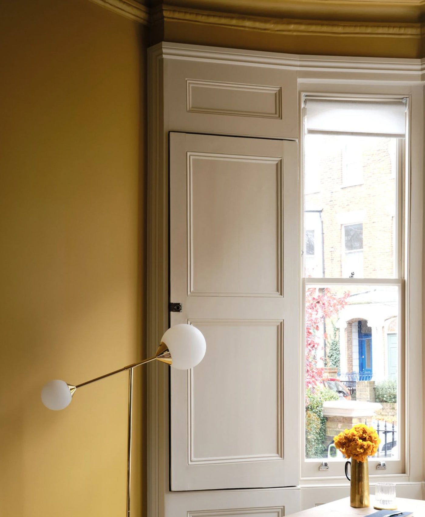 victorian neutral painted wooden shutters in mustard yellow living room