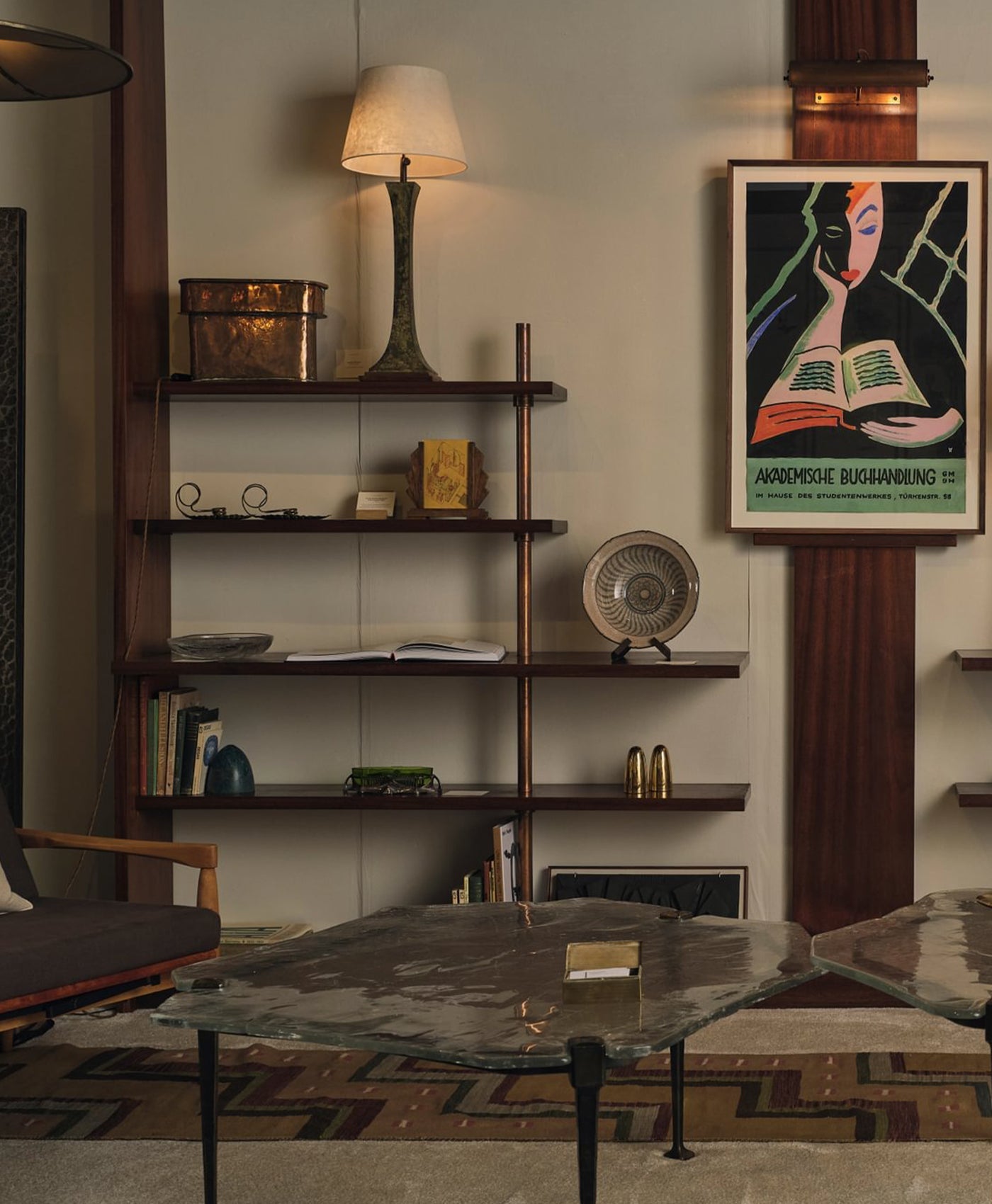 Stone coloured living room with a bookshelf, table, and wall art