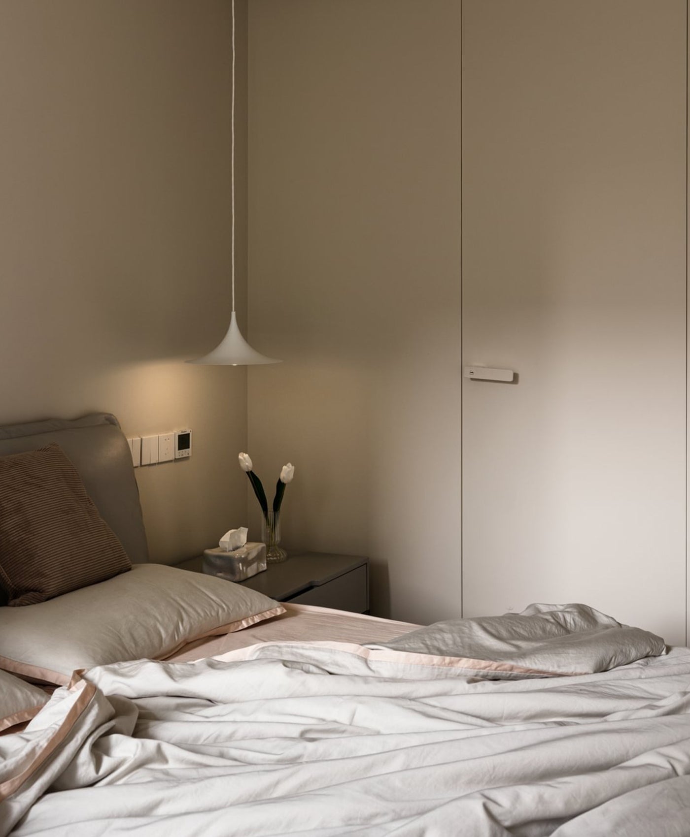 Bedroom with a bed, nightstand, and wall-mounted light fixture.