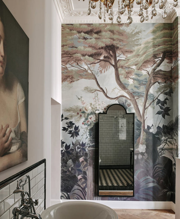 Decorative wall mural with floral and tree design and off-white paint on opposite wall, in a room with a chandelier.