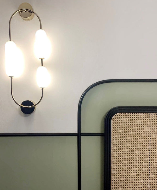 Modern bedroom with white and soft green wall, a rattan headboard with black trim
