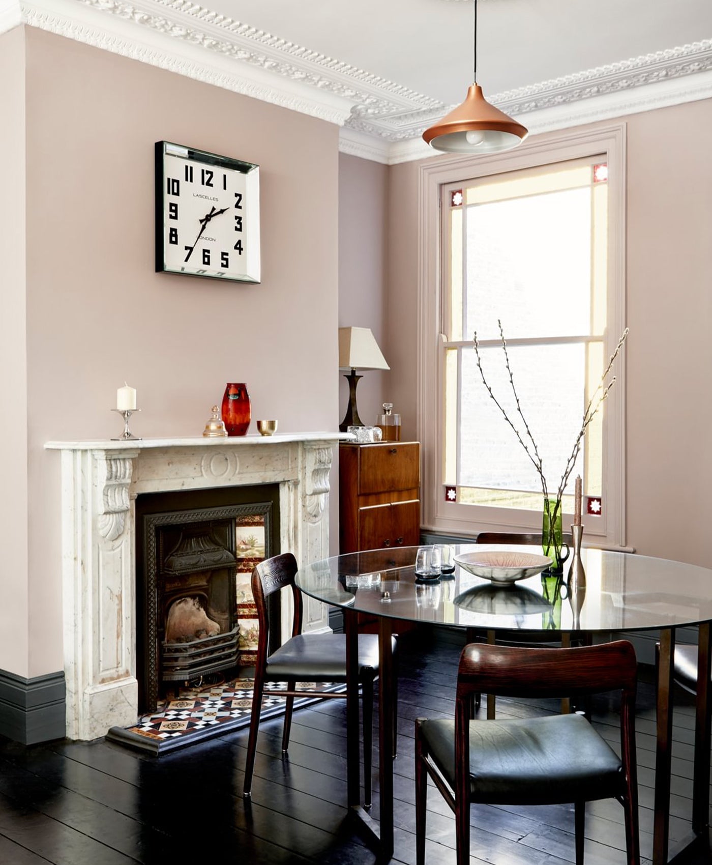 plaster pink Dining room with a fireplace, table, chairs, and decorative items.
