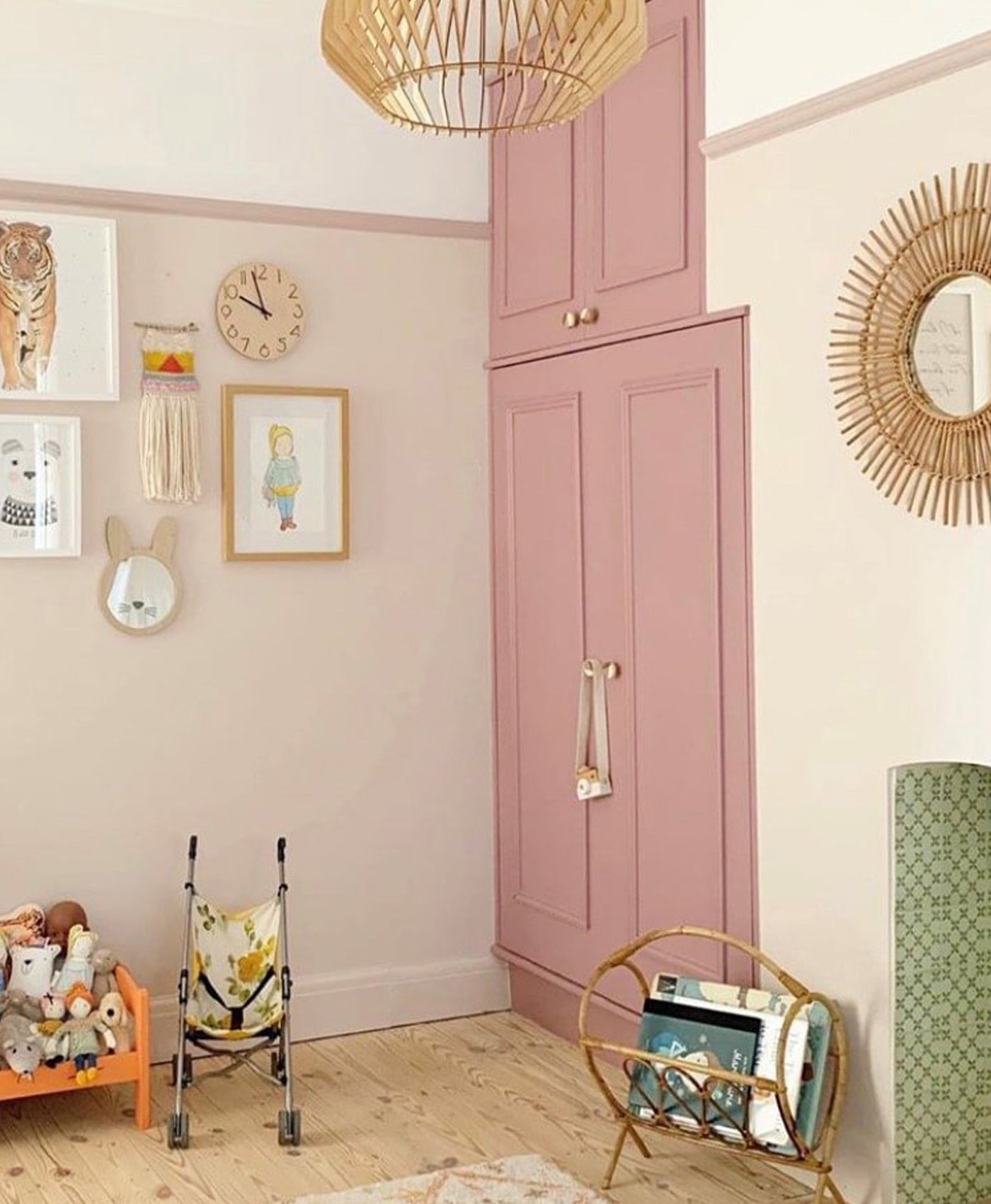 Children's room with muted pink wardrobe, decorative items, and a small chair.