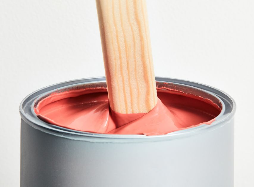 Dark red paint Indian Lake No.288 in a tin with a stirrer dipped in it